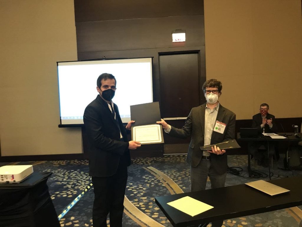 Photograph of Dr. Mohammad Miralinaghi receiving an award a certificate of appreciation from Dr. Gregory Rowangould at the T-R-B Annual Meeting