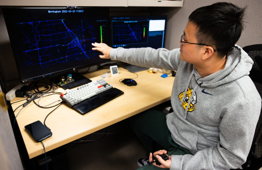 Xingmin Wang points at a computer screen