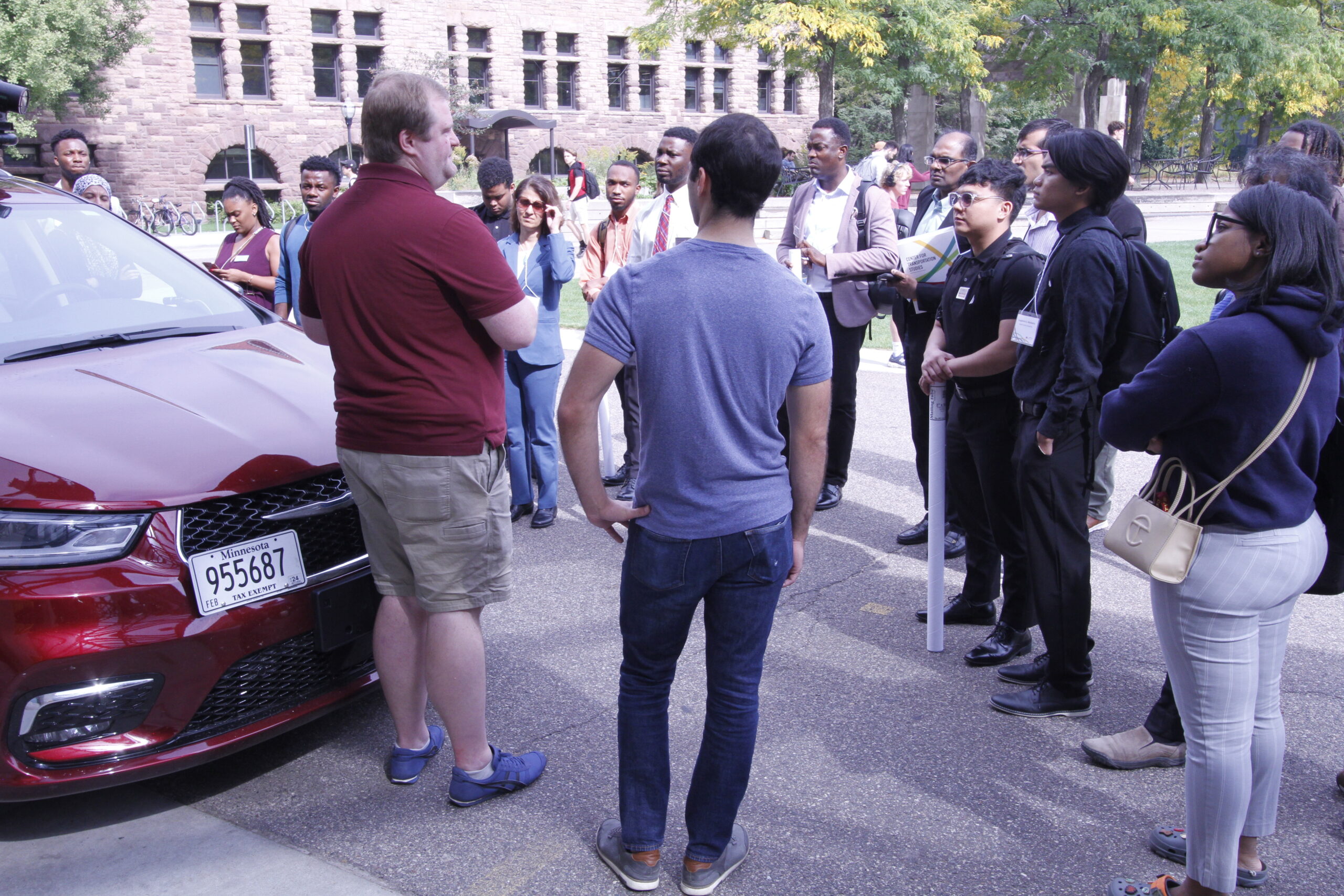 2023 campers touring Accelerated Vehicle Technology in Bloomington. Students on right side, instructors on left. 
