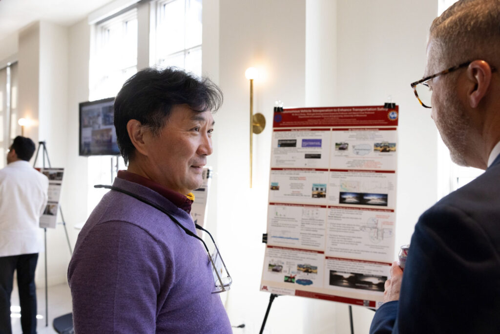 Zhi-Li Zhang speaks with attendee at the National Safety Summit