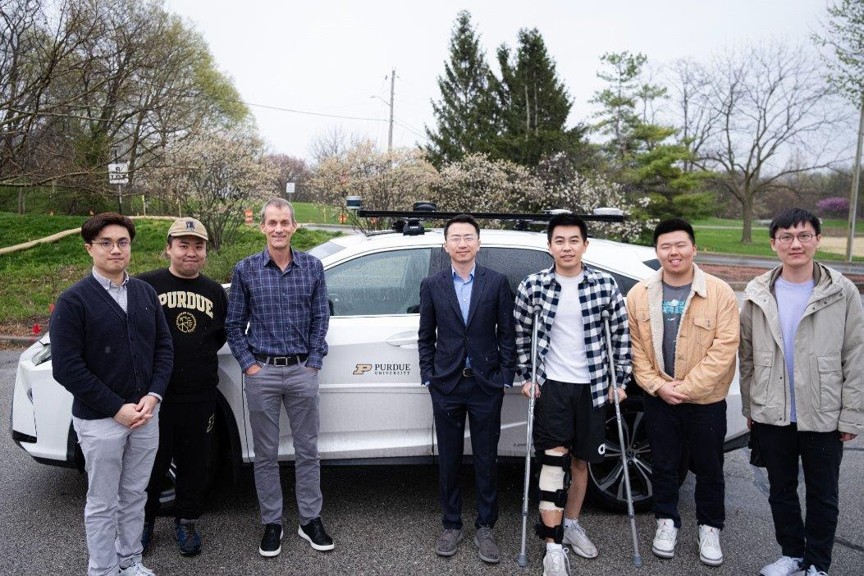 Ziran Wang LLM Team standing in front of a research vehicle